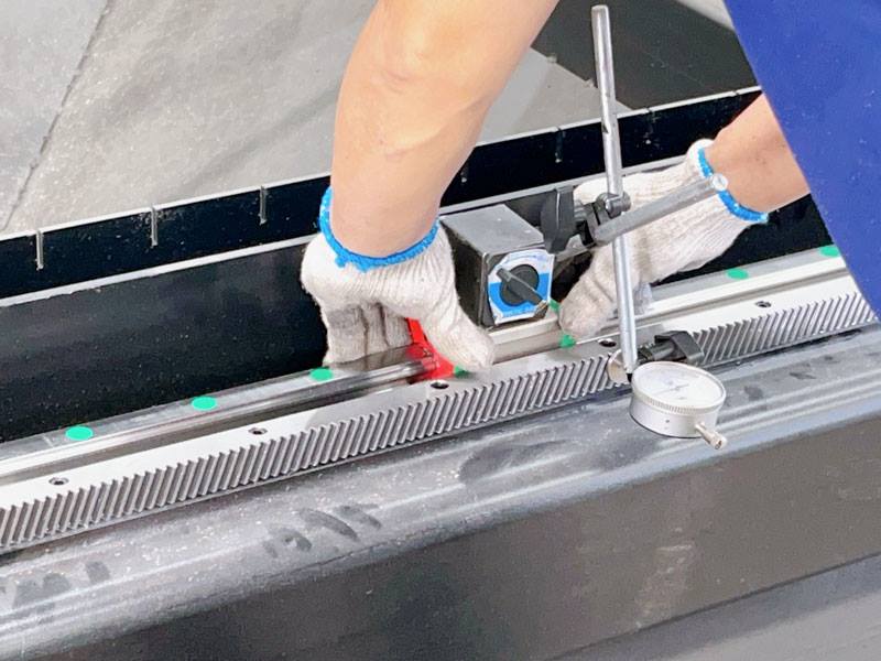 Technician inspecting the guide system accuracy of a laser cutting machine